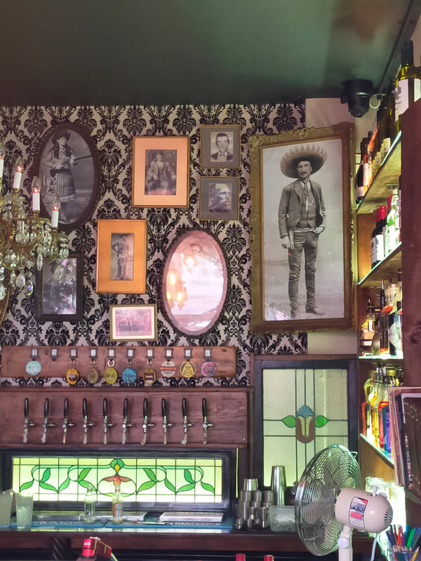 Picture shows the interior of Bandits, a cafe in Saltash, with old pictures of wild west bandits on the walls.