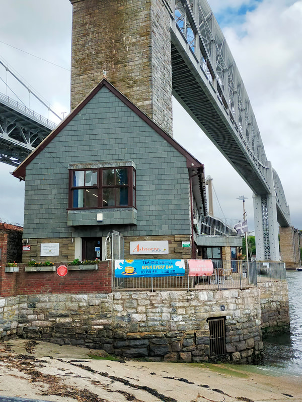 Picture shows a small two-storey building beneath the Royal Albert Bridge in Saltash, which houses the Ashtorre Rock community centre and tearoom.